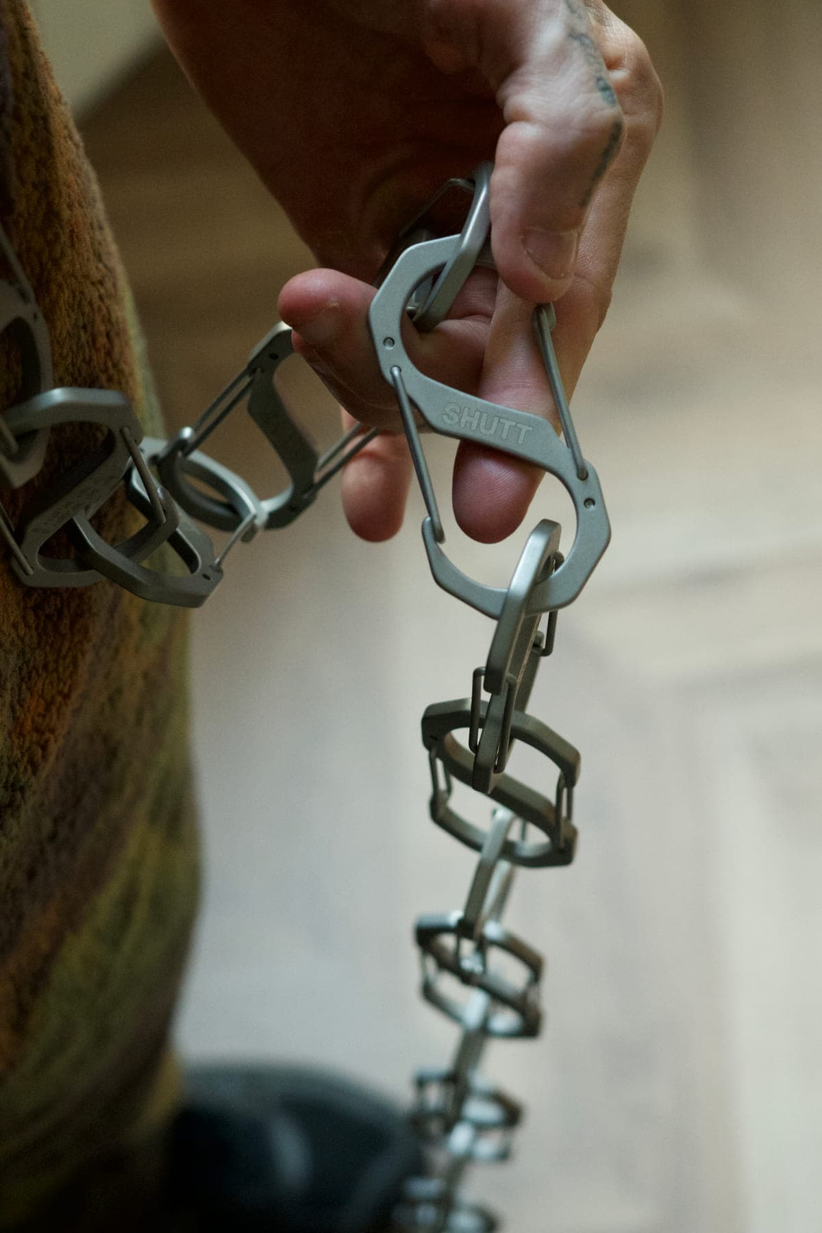 A chain of S-CARABINERs held in hand, SHUTT engraving visible