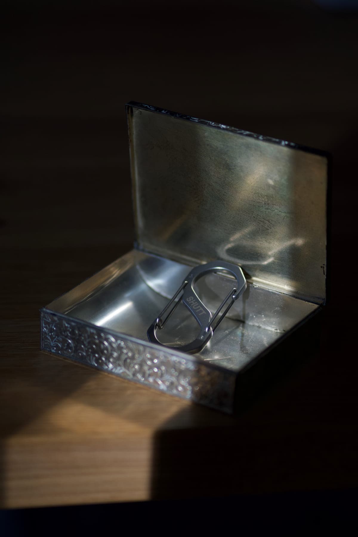 S-CARABINER resting in an engraved metal box